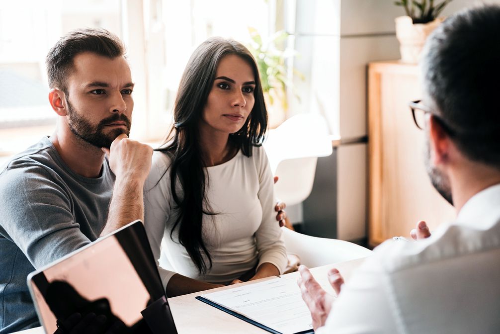 young couple listening to mortgage loan officer diring consultation