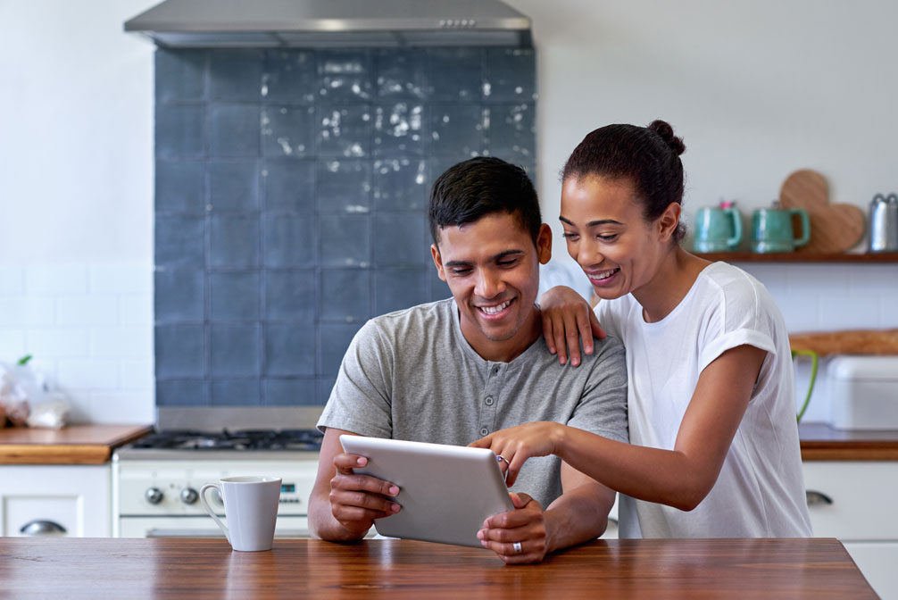 Happy couple using device to view real estate property virtual tour