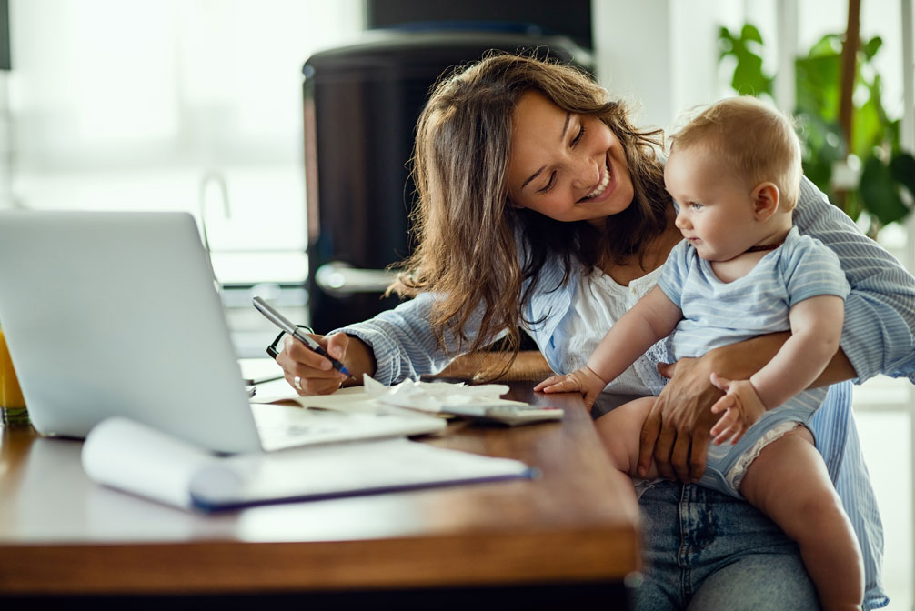 Happy mother with child on lap looking over family finances