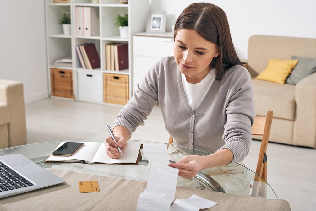 Woman looking at receipts looking for ways to save for down payment on mortgage